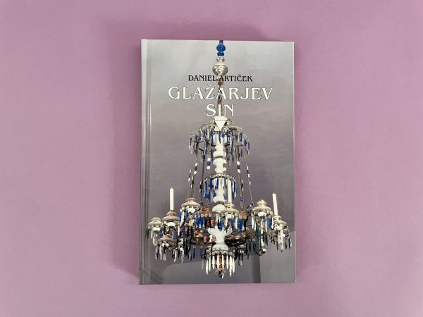 Knjiga Glažarjev greh je prikazana na gladki sivkasti podlagi, na naslovnici pa je bel in moder okrašen lestenec.