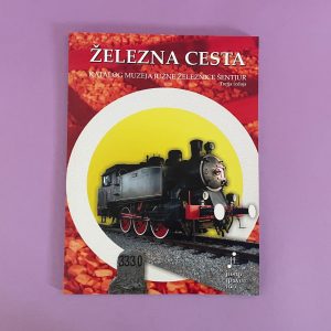 Železna cesta je knjiga s parno lokomotivo na naslovnici, ki je postavljena na svetlo rumeno-belo krožno ozadje z vijolično barvo pod njim.